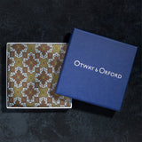 Tile design silk pocket square in brown, green and turquoise folded neatly in Otway & Orford branded blue gift box.