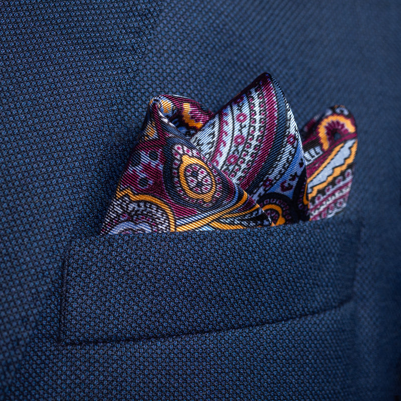 Intricate paisley design silk pocket square in blue, burgundy & gold by Otway & Orford folded in top pocket