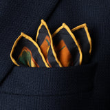 Exotic silk pocket square in gold, orange, green and blue using 1920s painting 'The Hunt' by Robert Burns which features Roman goddess Diana and her nymphs hunting. Here folded with points showing in top pocket of jacket.