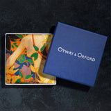 Exotic silk pocket square in gold, orange, green and blue using 1920s painting 'The Hunt' by Robert Burns which features Roman goddess Diana and her nymphs hunting. Here folded neatly in Otway & Orford branded blue gift box.
