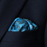 Tile design silk pocket square in navy, turquoise and brown by Otway & Orford folded in top pocket of blue jacket.