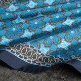 Close up of tile design silk pocket square in navy, turquoise and brown by Otway & Orford gently folded.