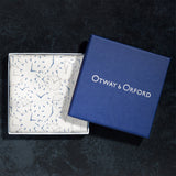 Watch dial design silk pocket square with white background and blue and grey watch dials folded neatly in Otway & Orford branded blue gift box.