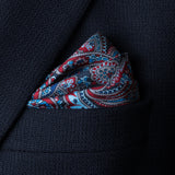 'Cypress' paisley silk pocket square in red and blue by Otway & Orford folded in top pocket of blue jacket.