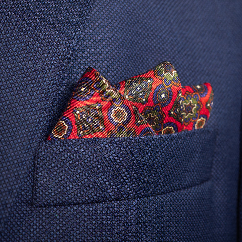 Millefiori silk pocket square in red, blue, green & white by Otway & Orford folded in top pocket