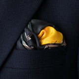 Silk pocket square featuring iconic US muscle car in Highland Green on orange background folded in top pocket of navy jacket.