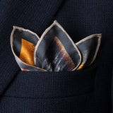 Silk pocket square featuring iconic US muscle car in Highland Green on orange background folded with points showing in top pocket of navy jacket.