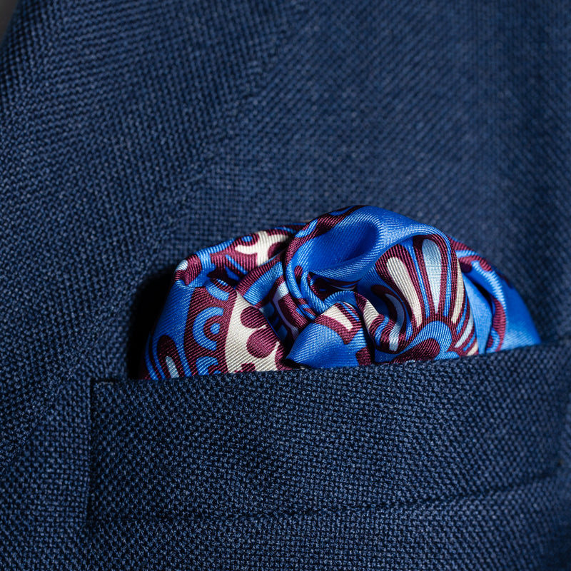Paisley design silk pocket square in blue, burgundy & cream by Otway & Orford folded in top pocket