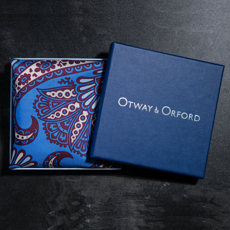 Paisley design silk pocket square in blue, burgundy & cream by Otway & Orford folded in gift box