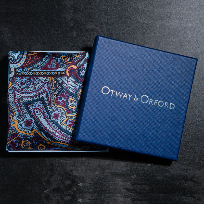 Intricate paisley design silk pocket square in blue, burgundy & gold by Otway & Orford folded in gift box